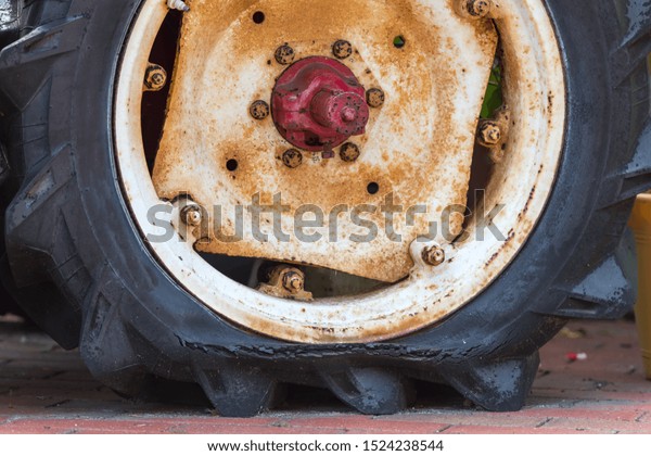 Old rusty tractor\'s flat\
back tire.