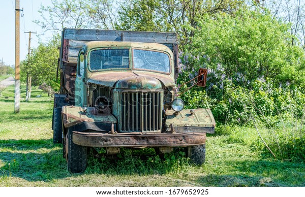 Old rusty\
truck on the green spring rural\
field