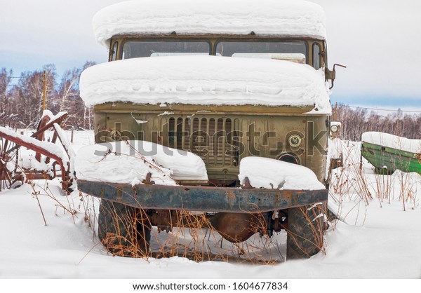 old rusty truck in the\
snow front view