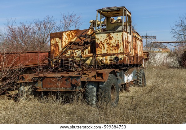 Old rusty truck thrown in desert of car park in\
ghost town of Pripyat, Chernobyl, Ukraine. Old rusty ancient car,\
Broken abandoned ancient rusty iron car. Radiation Zone, Stalker,\
Apocalypse Park USSR