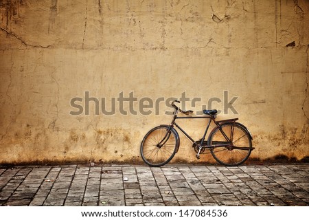 Old rusty vintage bicycle near the concrete wall
