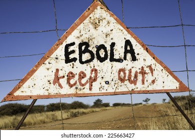 Old Rusty Warning Triangle At A Fence In Africa  With The Words Ebola Keep Out