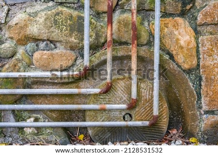 Old and rusty water pipes and pipe joints on stone wall