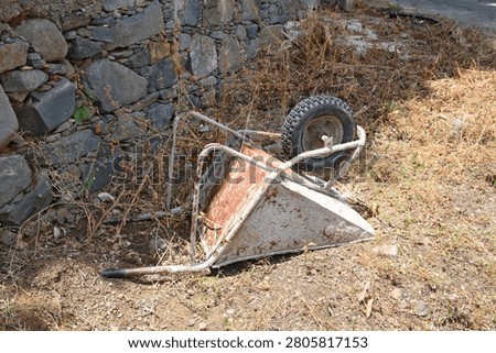 old rusty wheel barrow dumped in a field