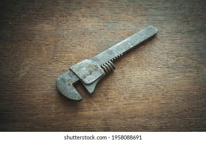 An Old Rusty Wrench On A Wooden Table