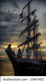 An Old Sailing Ship At Dockside At Sunset.