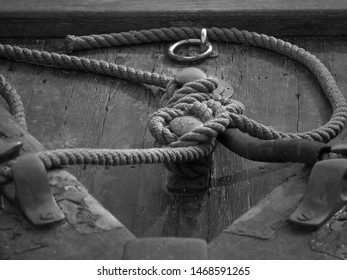 old sailor's knot on a boat deck in wood with old metal pieces and scratched wood.