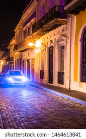 Old San Juan Puerto Rico Street Seen At Night With Old Architecture And Car In Cobblestone Street.