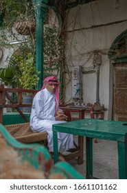 An Old Saudi Man Sits On A Balcony In The Old City Of Jeddah, Saudi Arabia 2020