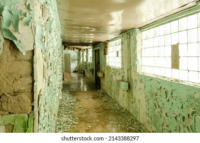 Old, Scary Hallway With Green Cracked Paint, Radiators And Windows. Forgotten, Abandoned Ghost Town Skrunda, Latvia. Former Soviet Army Radar Station.