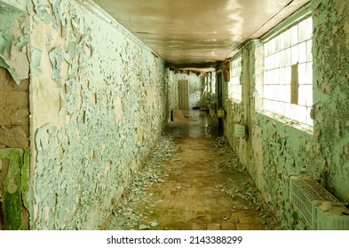 Old, Scary Hallway With Green Cracked Paint, Radiators And Windows. Forgotten, Abandoned Ghost Town Skrunda, Latvia. Former Soviet Army Radar Station.