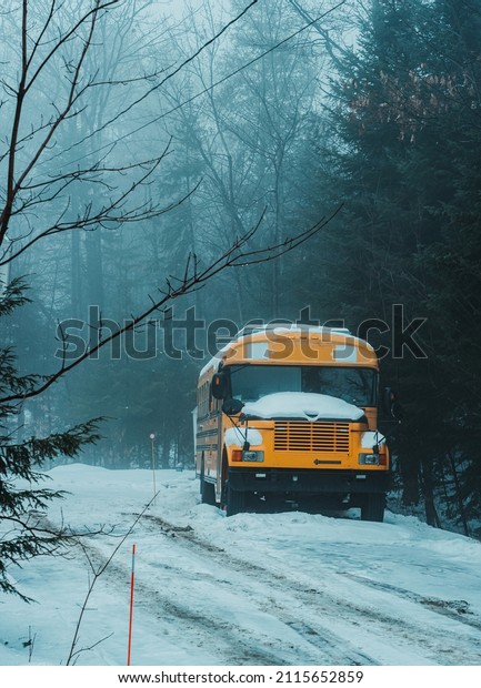 old school bus\
parked and covered in snow