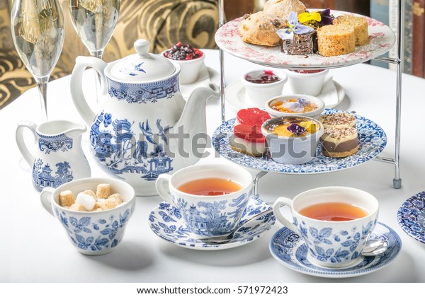 old school style tea at five afternoon service sandwich\
set cake sweet traditional table hotel cheesecake sugar pot blue\
china cup 