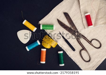 Old scissors, spools of colored thread, centimeter and tailors chalk, flat lay, concept of sewing clothes