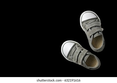 Old Secondhand Black Canvas Shoes Or Sneakers For Kids Or Baby And Child Foot On Black Background Top View With Copyspace Isolated Included Clipping Path