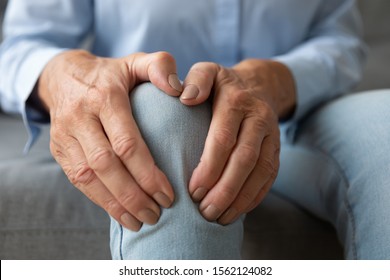 Old Senior Adult Woman Female Hands Touching Knee Sitting Alone, Retired Elderly Grandma Feeling Hurt Joint Pain In Leg Suffering From Osteoarthritis Bones Disease Or Injury Concept, Close Up View