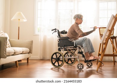 Old Senior Asian Female Tattoo Using Art Therapy While His Legs Is Injured At Home,asian Elder Woman Spend Recovering Of Her Leg Is Getting Better With Painting Canvas Art In Living Room At Home