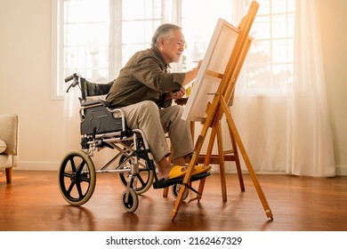 Old Senior Asian Male Using Art Therapy While His Legs Is Injured At Home,asian Elder Man Spend Recovering Of His Leg Is Getting Better With Painting Canvas Art In Living Room At Home