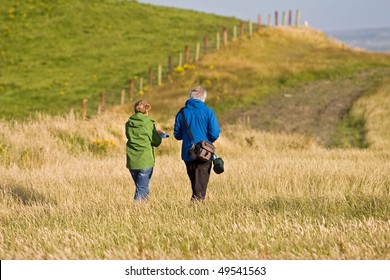 Old senior citizen couple taking a walk in the field in Ireland - Powered by Shutterstock