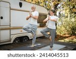 Old senior elderly couple spouses grandparents balancing in yoga position, slimming stretching while traveling in camper van motor home trailer. Eco-tourism