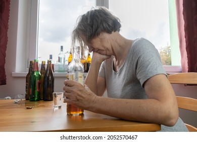 Old Senior Female Woman Sit Next To Table Drink Alcohol Bottle At Home Sad Alone Alcoholism Signs And Symptoms Rehab Abuse And Recovery Problems
