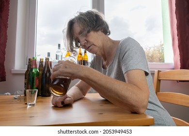 Old Senior Female Woman Sit Next To Table Drink Alcohol Bottle At Home Sad Alone Alcoholism Signs And Symptoms Rehab Abuse And Recovery Problems