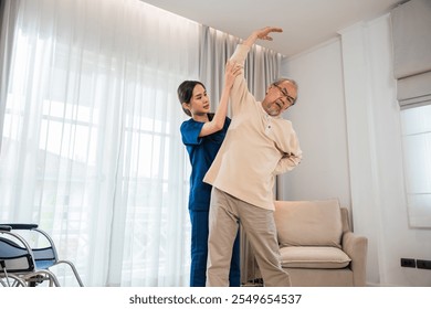 Old senior man enjoys training with physiotherapist for outstretched arms at home, Asian physical therapist patient nursing helping elderly exercising arm stretch, Rehabilitation of disabled concept - Powered by Shutterstock