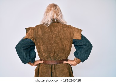 Old Senior Man With Grey Hair And Long Beard Wearing Viking Traditional Costume Standing Backwards Looking Away With Arms On Body 