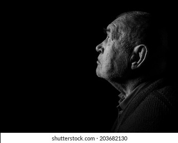 Old Senior Man Looking Up Praying In Dark Monochrome Image