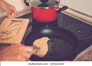 Old Senior And Mature Woman Is Cooking And Preparing Fish Or Something At The Kitchen At Home - Alone And Siolated