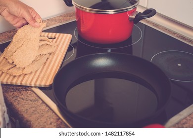 Old Senior And Mature Woman Is Cooking And Preparing Fish Or Something At The Kitchen At Home - Alone And Siolated