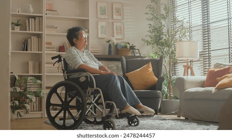 old senior retired woman in wheelchair Thoughtful asian senior woman sitting on wheelchair at home. Elderly female is looking through window elder woman in wheelchair alone at home - Powered by Shutterstock