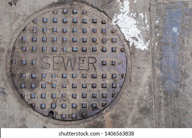 Old Sewer Cover On The Asphalt. 