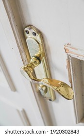 Old Shabby Doorknob In A White Door