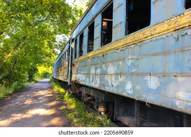 Old shabby wagon without windows. Decommissioned blue railway wagons. Rusty, peeling passenger wagons