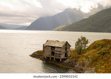 Old shelter on the mountains lake - Powered by Shutterstock