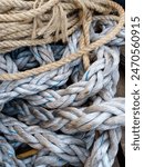 Old ship ropes in the harbor.  Frayed boat rope.  Massive nautical dirty shabby white ropes background texture close up. Selected focus of ropes. Close up pattern dirt Old ship ropes. Texture