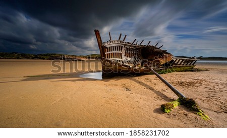 An old shipwreck boat abandoned stand on beach or Shipwrecked off the coast Bad Eddie Shipwreck - An old shipwreck found on the beach at Bunbeg, Donegal in Ireland.