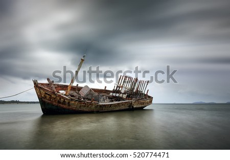 An old shipwreck boat abandoned stand on beach or Shipwrecked off the coast of Thailand.