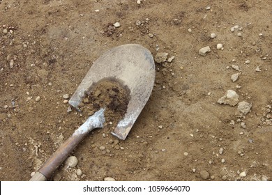 Old Shovel With Wooden Handle Digging Into The Dirt