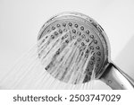 Old shower head, calcified. Old shower, water in shower head.