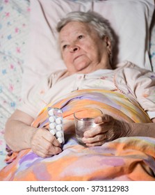 Old Sick Woman Lying At Bed, Going To Take The Medicine At Home