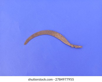 Old Sickle blade with rusty texture on isolated blue clean background
