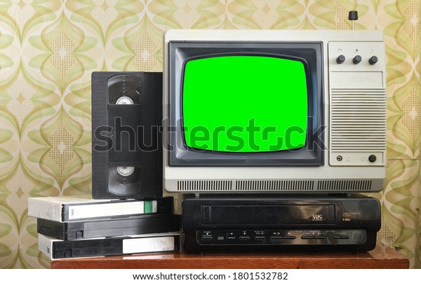 Old silver vintage\
TV with green screen to add new images to the screen, VCR on\
wallpaper background.