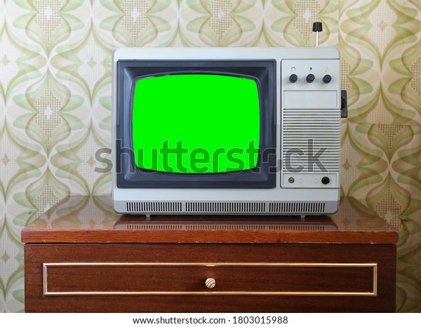 Old silver\
vintage TV with green screen for adding new images to the screen.\
Interior in the style of the\
1990s.