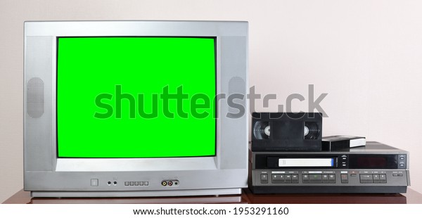 Old\
silver vintage TV with green screen to add new images to the\
screen, VCR on wallpaper\
background.	1980s,1970s.