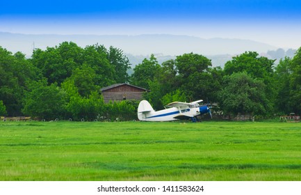 Old Small Airplane On The Farm Field.