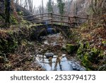 old small stone bridge over an alpine stream on an alpine trail in Val Brenbana in Lombardy Italy