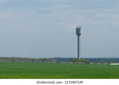 Old Small Town Water Tower Against A Sunset Sky.