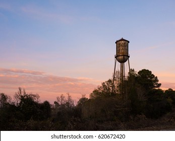 Old Small Town Water Tower Against A Sunset Sky.